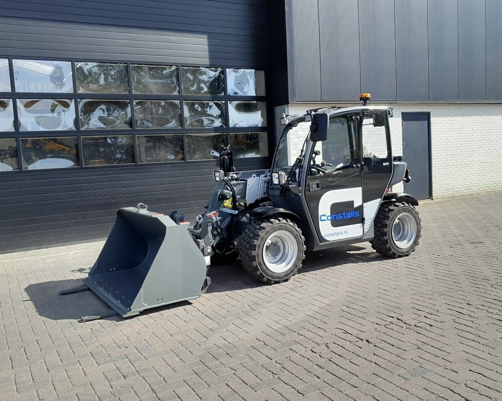 Kramer 1445 verreiker van Constalis BV met geheven bak
