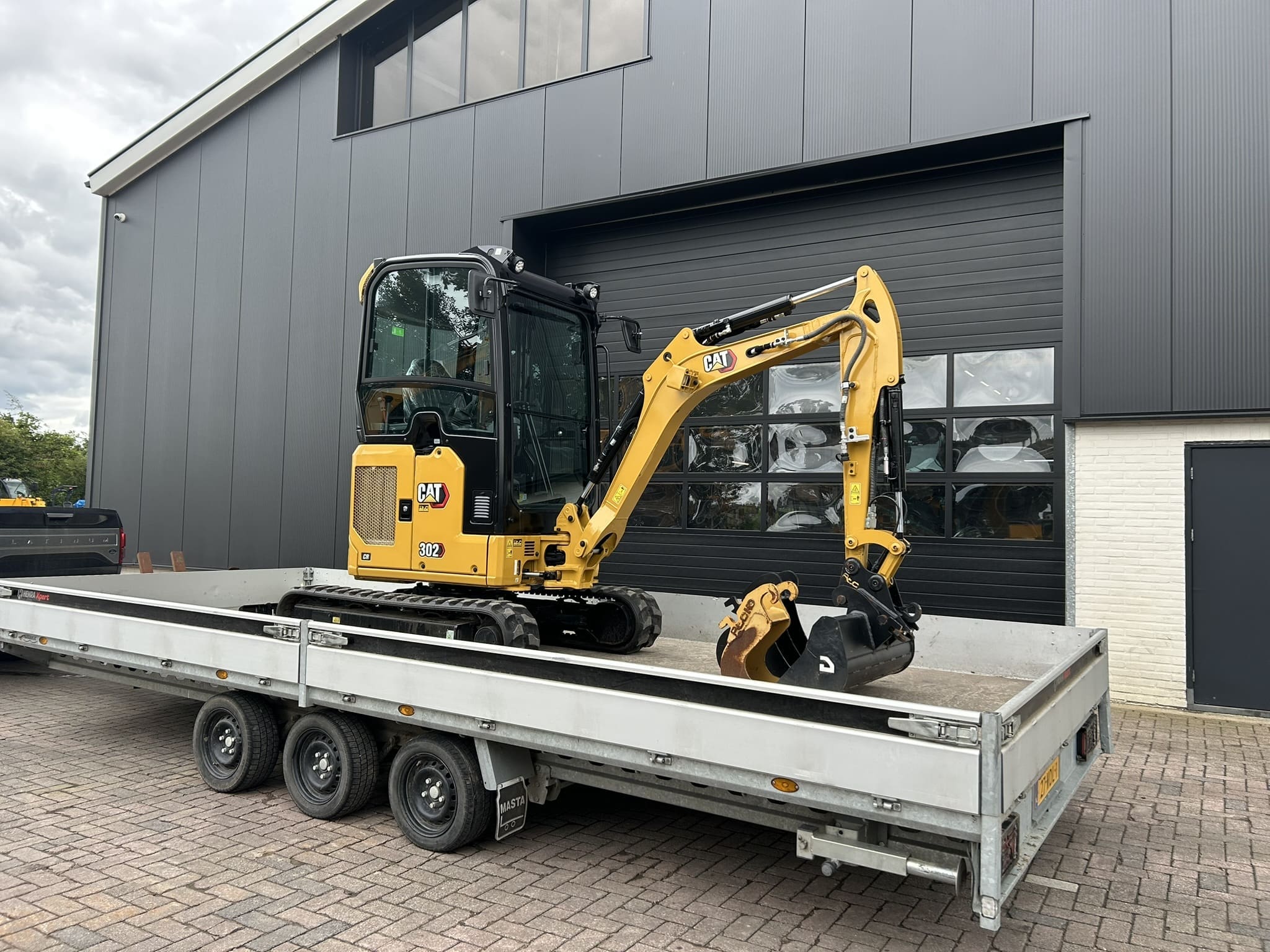 Cat 302 CR minigraafmachine voor Handelsonderneming GCK – vooraanzicht met giek